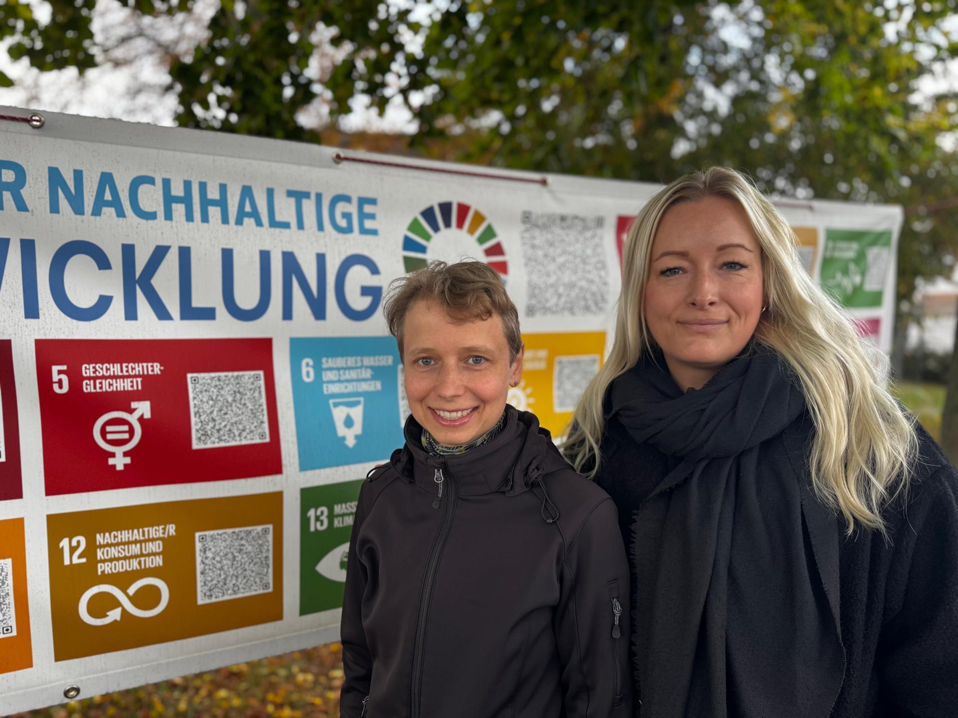 Die Initiatoren Susanne Troeger und Janine Friebel vor dem Plakat der 17 Ziele für nachhaltige Entwicklung an der Grundschule Am Park.  (Foto: Daniel Große)