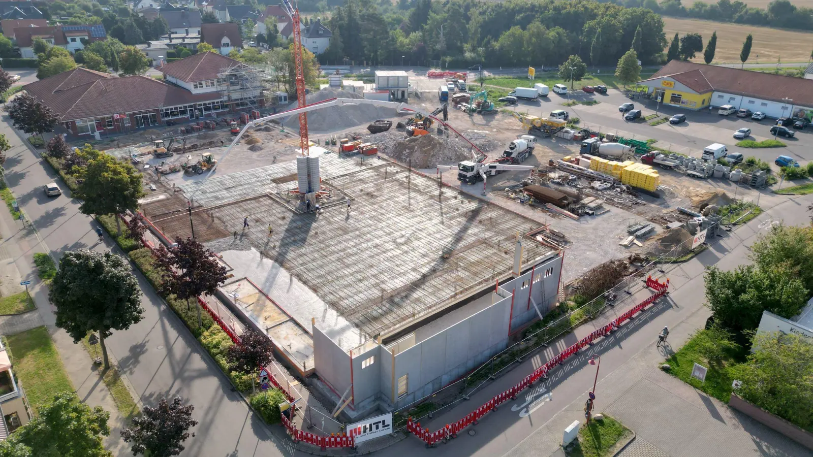 Beton, Stahl und Schwerlasttechnik im Einsatz: Auf der Baustelle des neuen REWE-Markts in Taucha wird die erste Bodenplatte gegossen – ein weiterer Schritt hin zum geplanten Green Building. (Foto: Daniel Große)