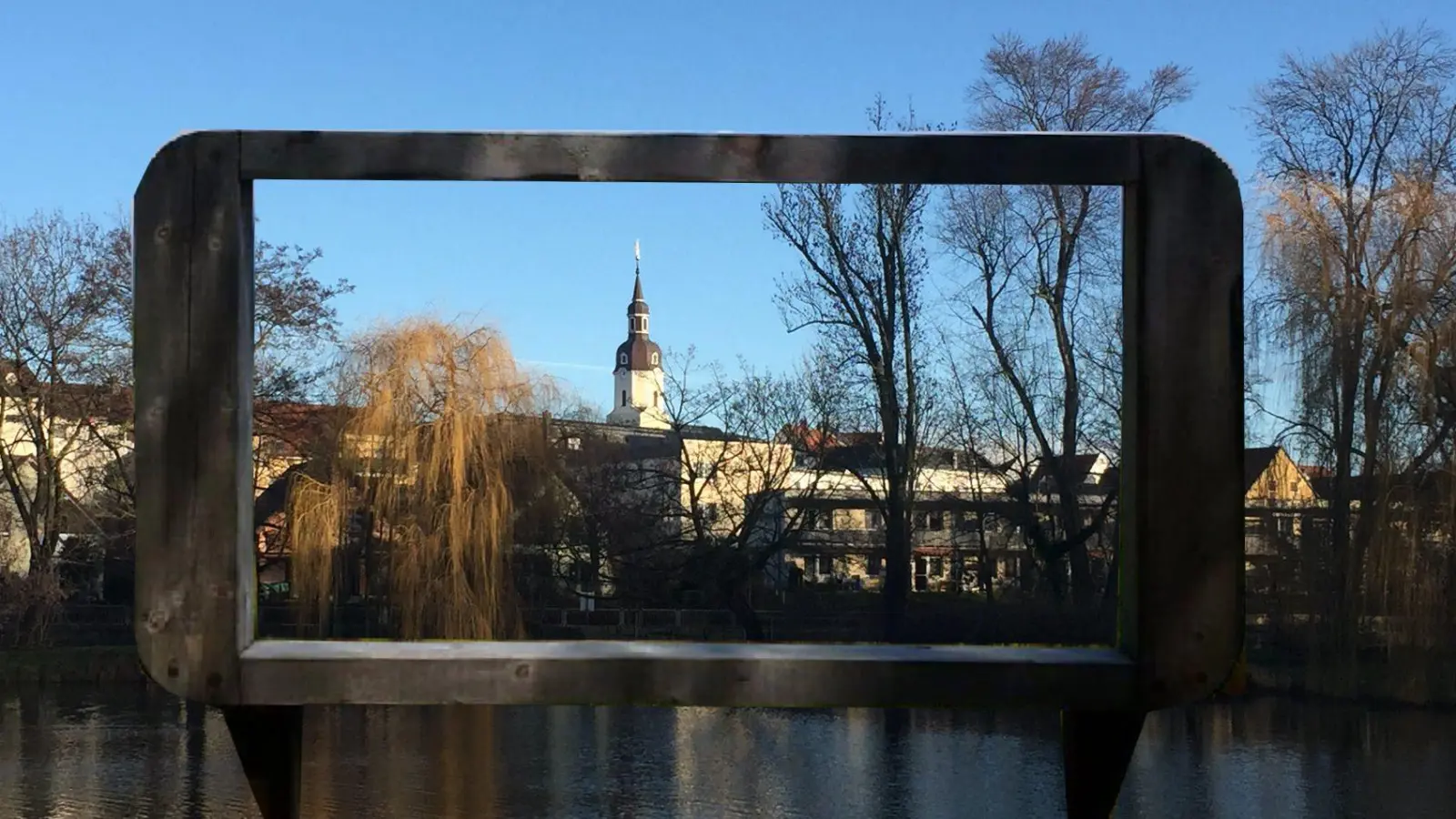 Hier noch aus Holz, später aus Cortenstahl* soll der Rahmen sein, den Barbara Stein am Schöppenteich aufstellen will. (Fotomontage) (Foto: taucha-kompakt.de)