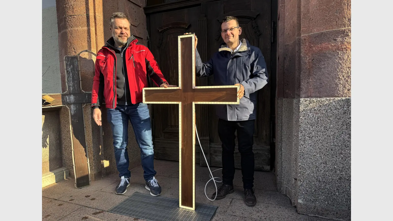 Heiko Zettelmann und Nico Piehler präsentieren die neuen Lichtkreuze für die Kirche St. Moritz. (Foto: Daniel Große)