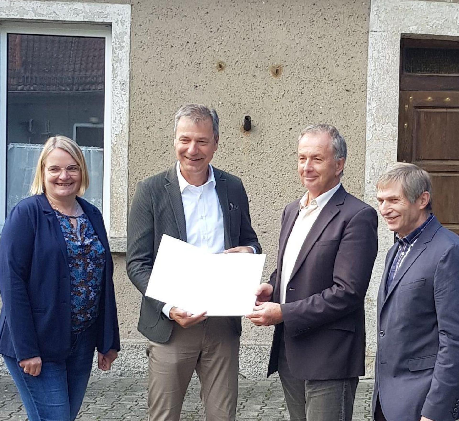 Bei der Übergabe des Fördermittelbescheids vor dem Gebäudekomplex „Alte Schule“: Mockrehnas Bauamtsleiterin Jana Dietze, Nordsachsens Landrat Kai Emanuel, Mockrehnas Bürgermeister Peter Klepel und Audenhains Ortsvorsteher Lothar Haupt (von links). (Foto: Landratsamt Nordsachsen / Horn)