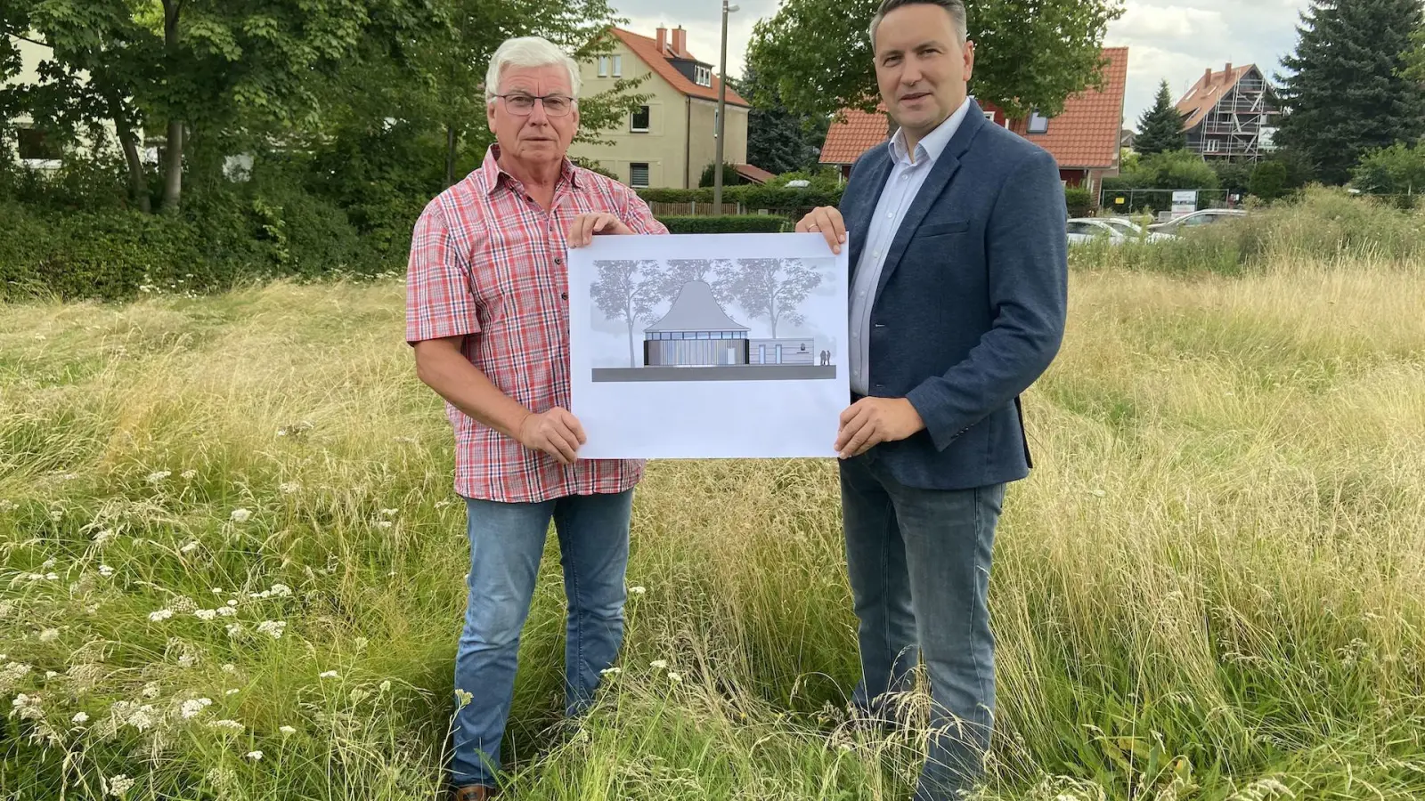 Sebastian Kräher, amtierender und Eckhard Nadoldny, ehemaliger Gemeindevorsteher der Neuapostolischen Kirche Taucha präsentieren den Bauplan des Kirchenneubaus an der Sommerfelder Straße. (Foto: taucha-kompakt.de)