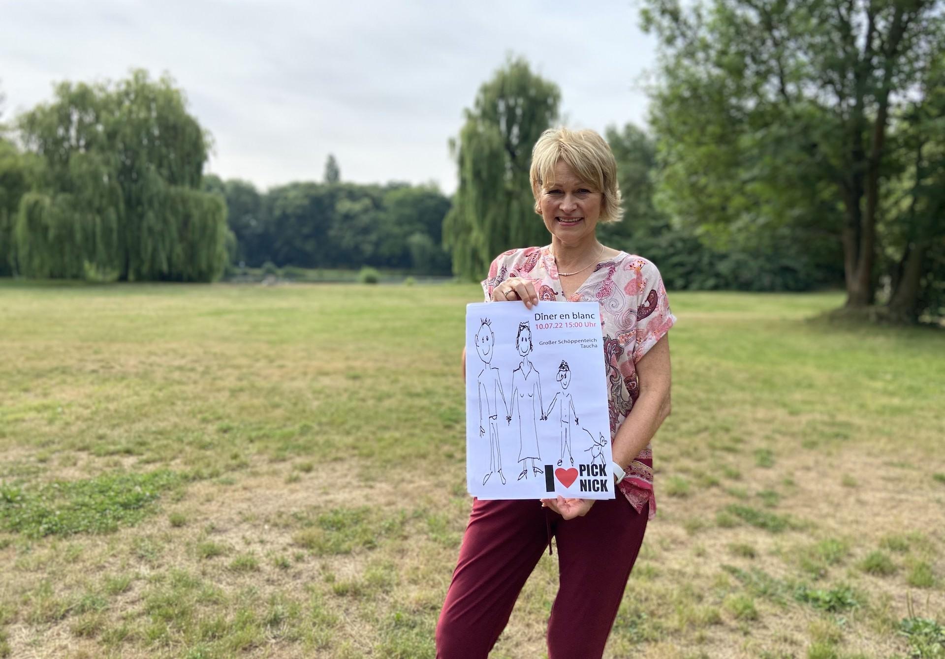 Karin Bell zeigt das Veranstaltungsplakat (Foto: taucha-kompakt.de)