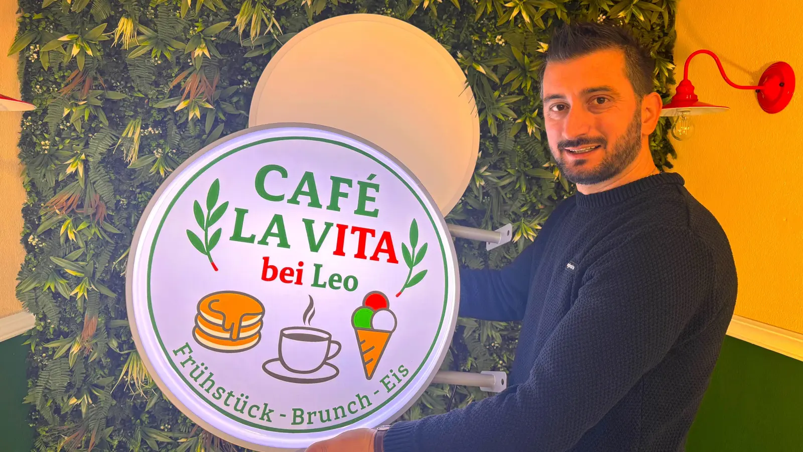Leonard Muca mit dem Logo seines Cafés, das er im Frühjahr eröffnen wird. (Foto: Daniel Große)