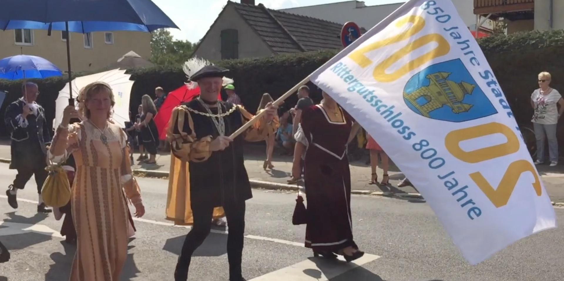 Michael König, einstiger Kämmerer Tauchas, schwenkt zum Tauchscher 2019 die Fahne des Doppeljubiläums 2020. (Foto: taucha-kompakt.de)